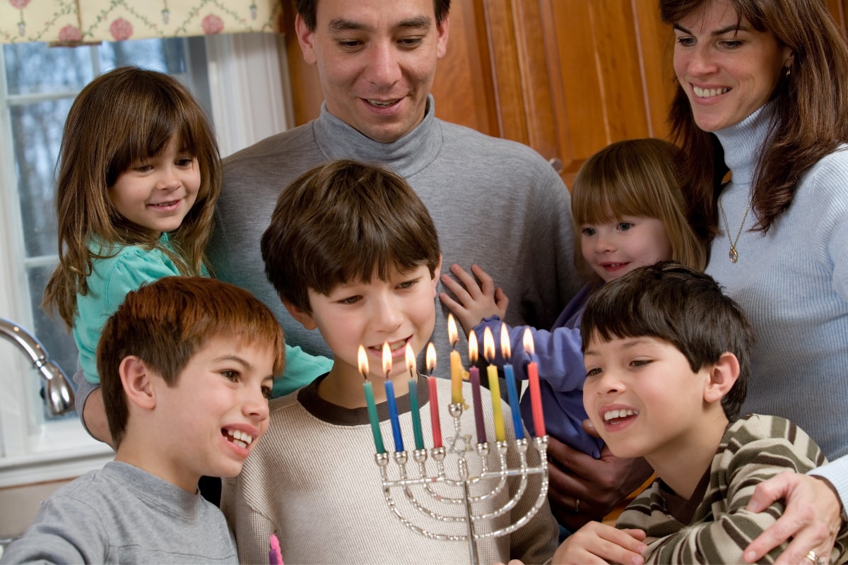 family lighting hanukkah menorah