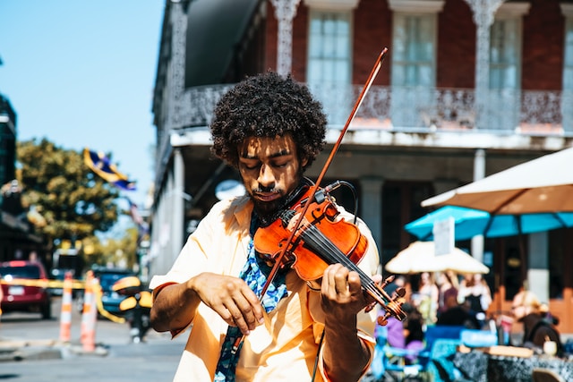 A man playing the violin or fiddle on the streets in the summer day