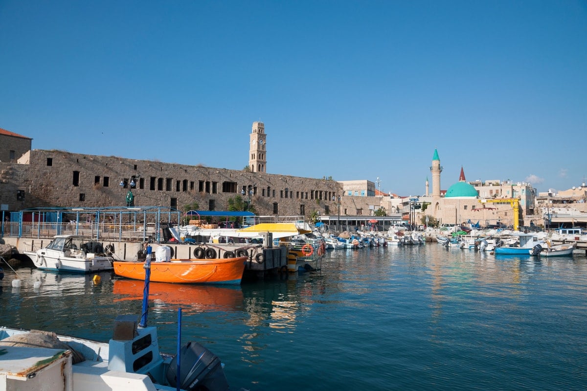 the acre port with boats docked in front of the old city
