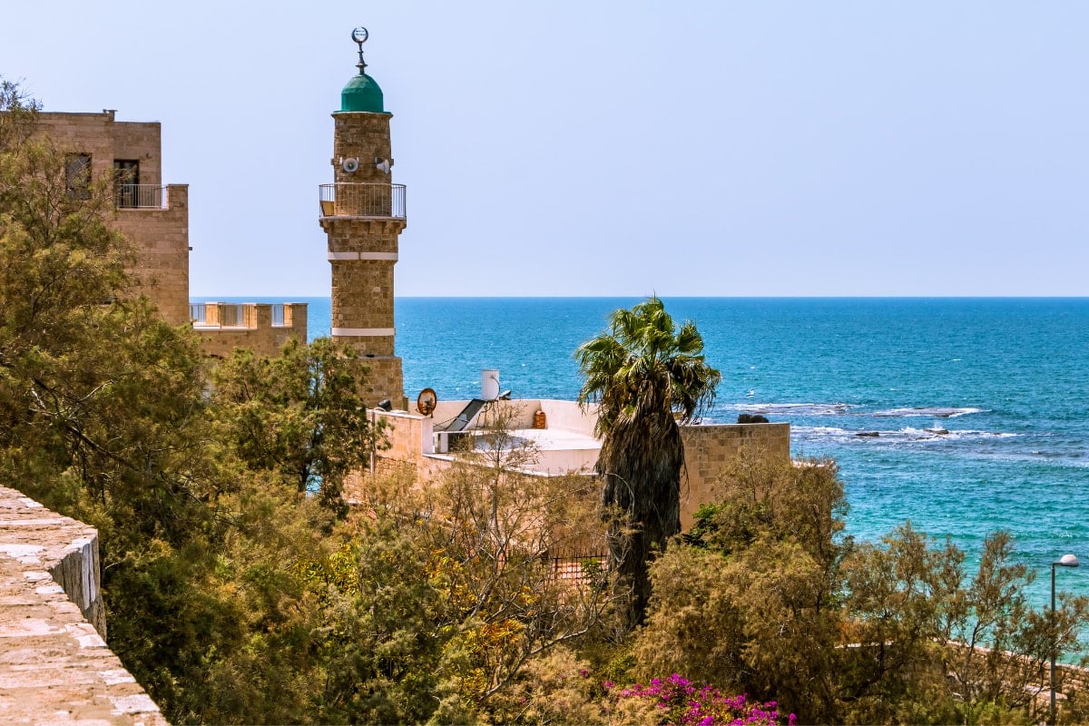 a mosque in the city of Jaffa with the Mediterranean sea behind it